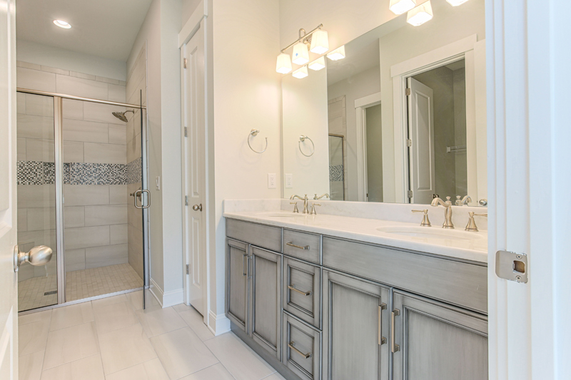 Grey Cabinets and dual sink vanity with walkin shower