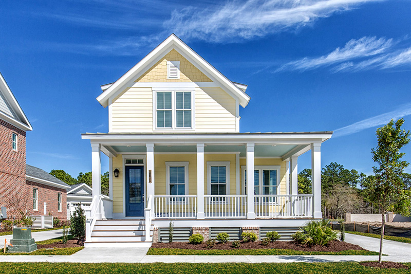 Yellow two story home big front porch The Cooper home plan